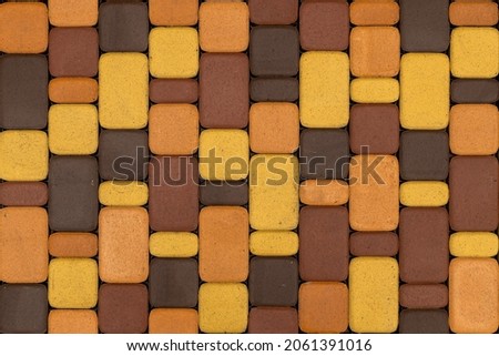 seamless texture and flat background of brown and yellow artificial stone pavement - rectangular shape with rounded corners