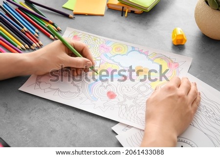 Woman coloring picture at table
