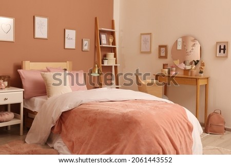 Teenage girl's bedroom interior with stylish furniture and beautiful decor elements