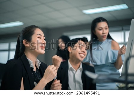 Three excited employees reading good news on line in a computer desktop at office