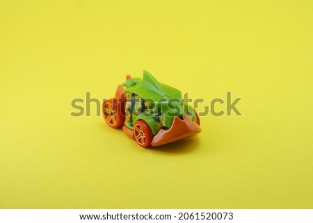 isolated yellow background photo. a small hot wheels toy that imitates the shape of a green fish monster