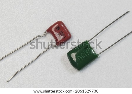 Red and green mylar capacitors on white background isolated. Closeup macro shots. Royalty-Free Stock Photo #2061529730