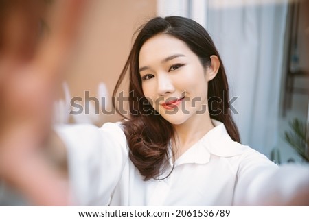 Portrait of a happy young asian girl holding smartphone and taking picture of herself at home.  Beauty and Healthy Woman. Happy woman lifestyle concept.