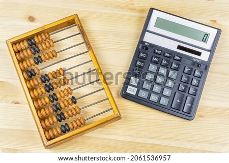 Old antique wooden abacus and modern calculator close-up. Progress in accounting, business, account.