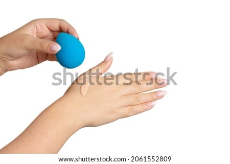 Woman holding beauty blender with a drop of a liquid foundation on her hand. Isolated, space for text