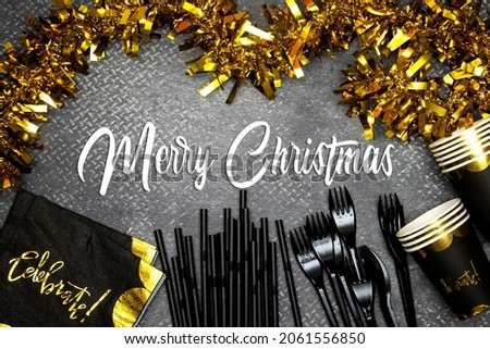 Christmas party concept, paper napkin with celebrate text and disposable cup, fork and straws and yellow tinsel