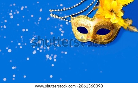 Carnival mask on blue background with silver beads. Festivals or Mardi Gras concept. Copy space