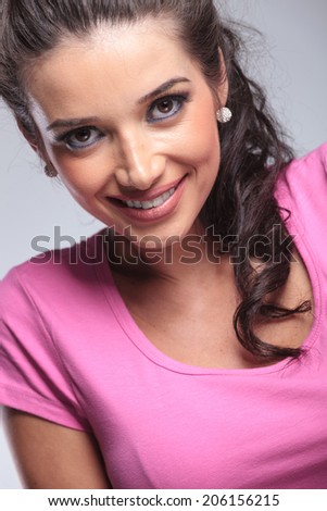 closeup picture of a young casual woman's face smiling in studio