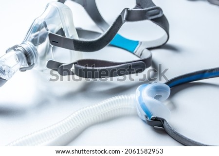 CPAP mask against obstructive sleep apnea helps patients respirator mask headgear clip for nose and throat breathing medication with cpap machine against snoring and sleep disorder to breath easier Royalty-Free Stock Photo #2061582953