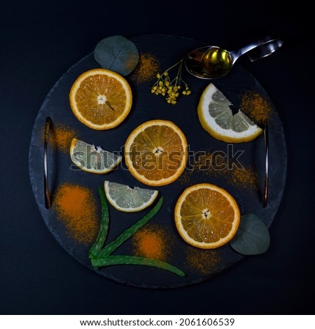 Creative layout made of season specific fruit and spices on a plate on dark background. Top view, flat lay. Minimal holidays concept.