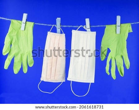 Disposable gloves  on a rope . Disposable gloves are used once . Let's say stop the coronavirus. Place for the test.  Medical gloves on a yellow background with copy space. Concept: stop the covid-19