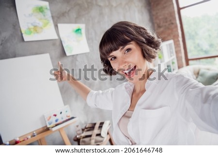Photo portrait young girl wearing casual outfit taking selfie showing thumb-up near blank canvas