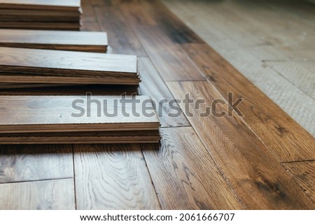 The process of house renovation with changing of the floor from carpets to solid oak wood. Beautiful golden handscraped oiled European oak brushed for added texture and fine definition of wood grain Royalty-Free Stock Photo #2061666707