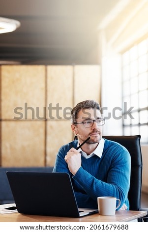 Shot of a mature businessman working on his laptop in the office Royalty-Free Stock Photo #2061679688