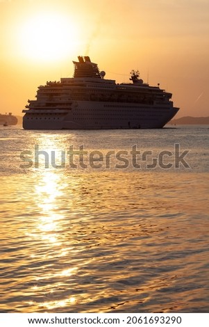 Transatlantic ship departing from the port of Santos, Brazil, during the summer sunset. Royalty-Free Stock Photo #2061693290