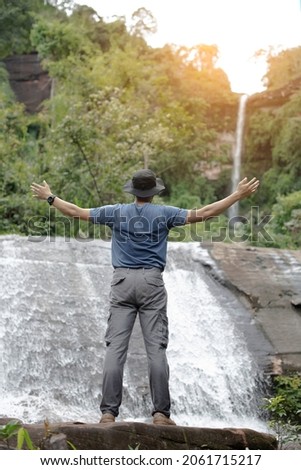 backside of asian men love to travel and trek, take pictures of Thai men in Asia. Take yourself for a walk on the waterfall in the tropical forest