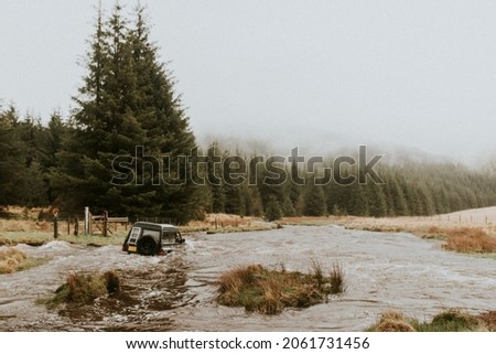 Off-roading car stuck in the water stream in nature