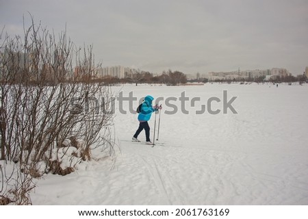 A woman skiing on a frozen city pond