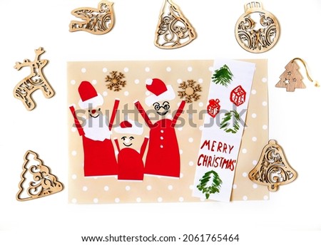 Child created Christmas greeting card.  Nice card with happy Santa family . Craft for children.