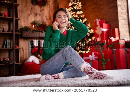 Photo of pretty funky young woman dressed green sweater talking modern device laughing hand arm head smiling indoors house home room