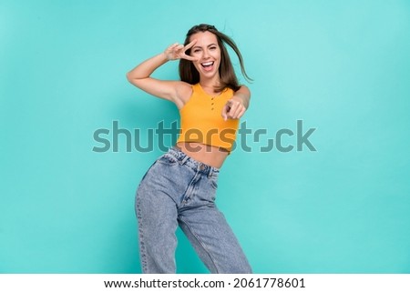 Portrait of excited positive lady fingers show v-sign near eye direct indicate you camera isolated on teal color background