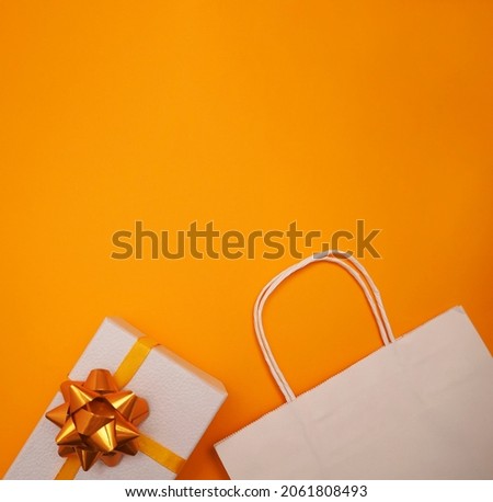  White gift paper bag and gift box on yellow background. Banner with copy space. Christmas, New Year, Birthday, shopping sales concept.                                 