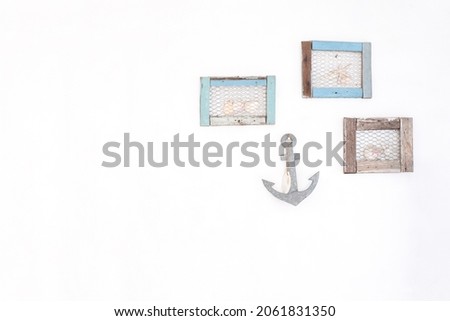 wooden picture frame and anchor, star fish and on white wall. vintage filtered image