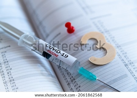 Third covid vaccine dose and jab concept. Three syringes are seen on calendar as a concept for the 3rd covid-19 vaccine dose, also called booster shot, now requested during the vaccination campaign. Royalty-Free Stock Photo #2061862568