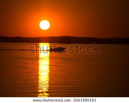 A boat crossing sun bridge in late evening, only silhouette visible Royalty-Free Stock Photo #2061880181
