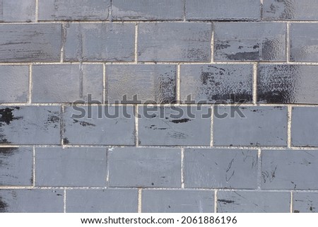 wall with old black glossy tiles. High quality photo