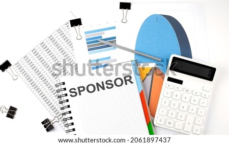 Text SPONSOR on a notebook on diagram and charts with calculator and pen