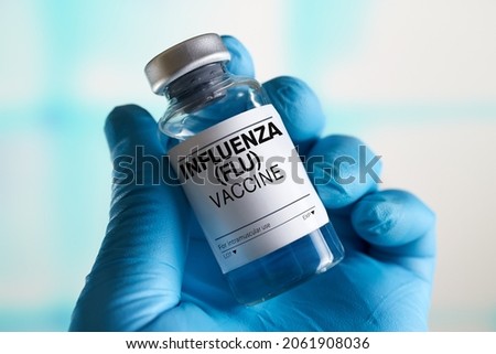 doctor with Influenza Flu or Grippe vaccine bottle for the annual flu disease prevention campaign. Influenza (Flu) Vaccine vial Royalty-Free Stock Photo #2061908036
