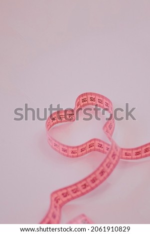 Measure tape on the pastel pink background. Mock up for body slimming, weight loss or dressmaker's offer or other ideas. Empty place for text, logo or object