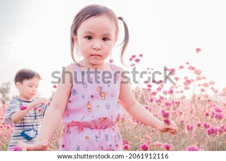 Cute little boy and girl at flower garden.  kid spending summer holidays. Soft focus. Copy space.