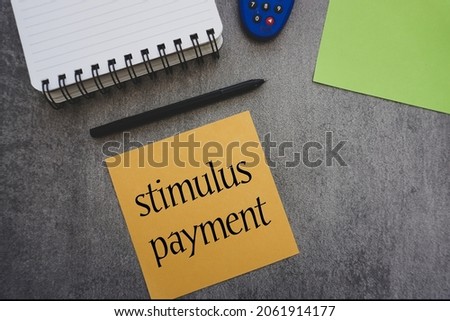 Stimulus payment word write on a sticky note isolated on cement background