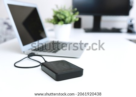 External backup disk hard drive connected to laptop Royalty-Free Stock Photo #2061920438