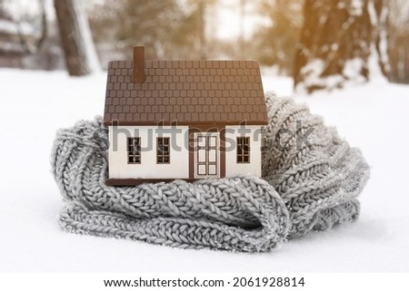 Figure of house and scarf on winter day. Concept of heating season