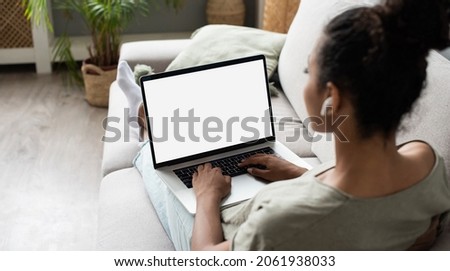 Young woman using laptop at home, student girl using laptop computer with blank white empty screen monitor. Online shopping, web site, working from home, online learning, studying concept.