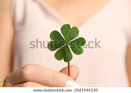 Woman holding green four leaf clover in hand, closeup Royalty-Free Stock Photo #2061944120