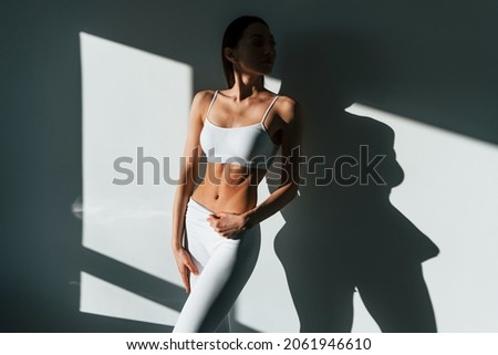 Beautiful lighting. Young caucasian woman with slim body shape is indoors at daytime. Royalty-Free Stock Photo #2061946610