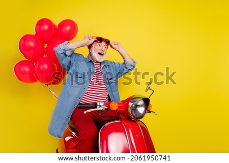 Portrait of elderly retired pensioner trendy man riding moped bargain black friday isolated over vivid yellow color background