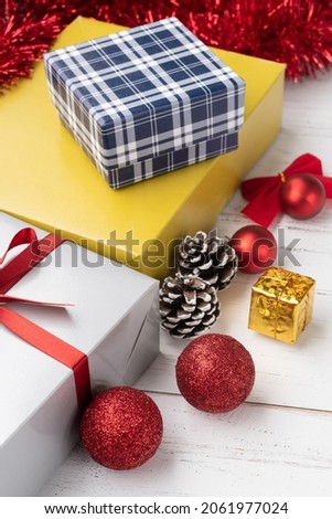 Gift box, christmas balls and bow over wooden table.