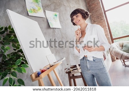 Full body photo of dreamy minded happy woman look canvas painter picture indoors inside house home flat