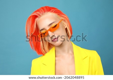 Beautiful young woman with bright dyed hair on turquoise background Royalty-Free Stock Photo #2062048895