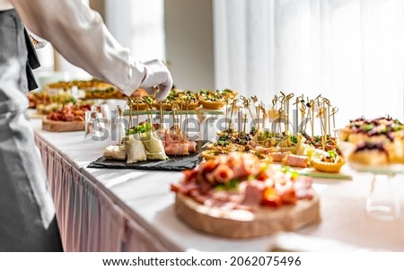 woman hands of a waiter prepare food for a buffet table in a restaurant Royalty-Free Stock Photo #2062075496