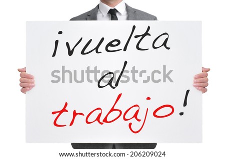 businessman holding a signboard with the text vuelta al trabajo, back to work in spanish, written in it