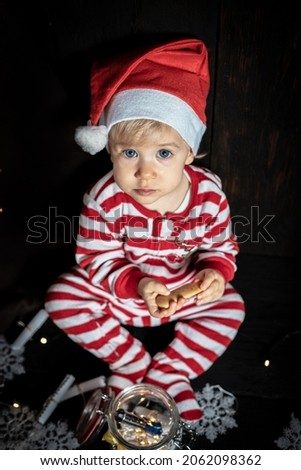 Cute baby boy searching for Christmas cookies. Baby's first Christmas.