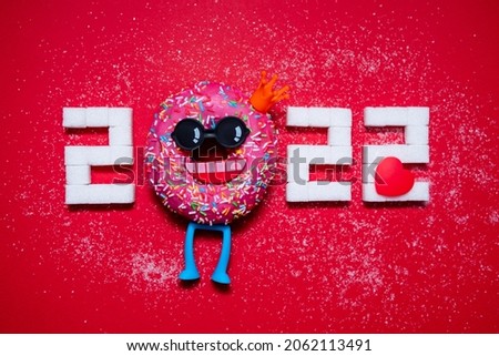 Numbers 2022 from doughnut and sugar. Conceptual photography. Diet. Banner. Business. New Year. Red background.