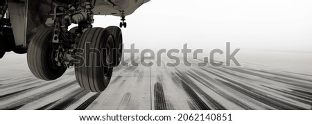 A view of a runway at one of the UK's largest growing airports. A passenger airline or cargo aircraft landing or taking off before the airport is engulfed by fog. Royalty-Free Stock Photo #2062140851