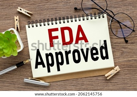 FDA Approved. text on white paper on wood background business concept